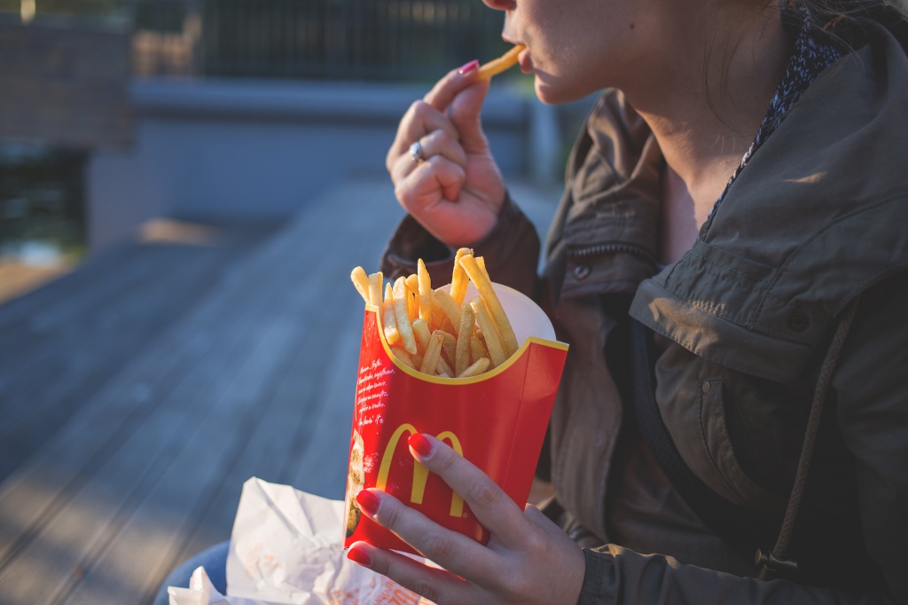 woman-in-brown-classic-trench-coat-eating-mcdo-fries-during-139681.jpg